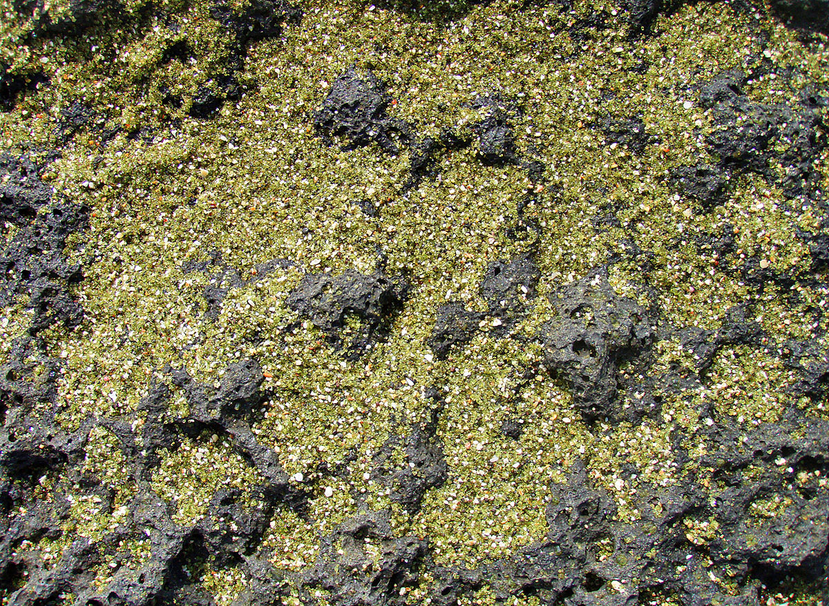 Green olivine sand on the lava beach