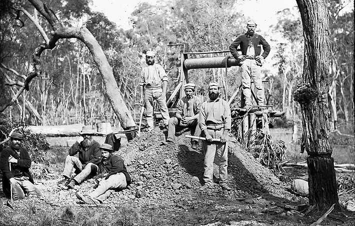 Historic photo of the amall gold minehead without shelter and seven gold miners, Gulgong, NSW, Australia