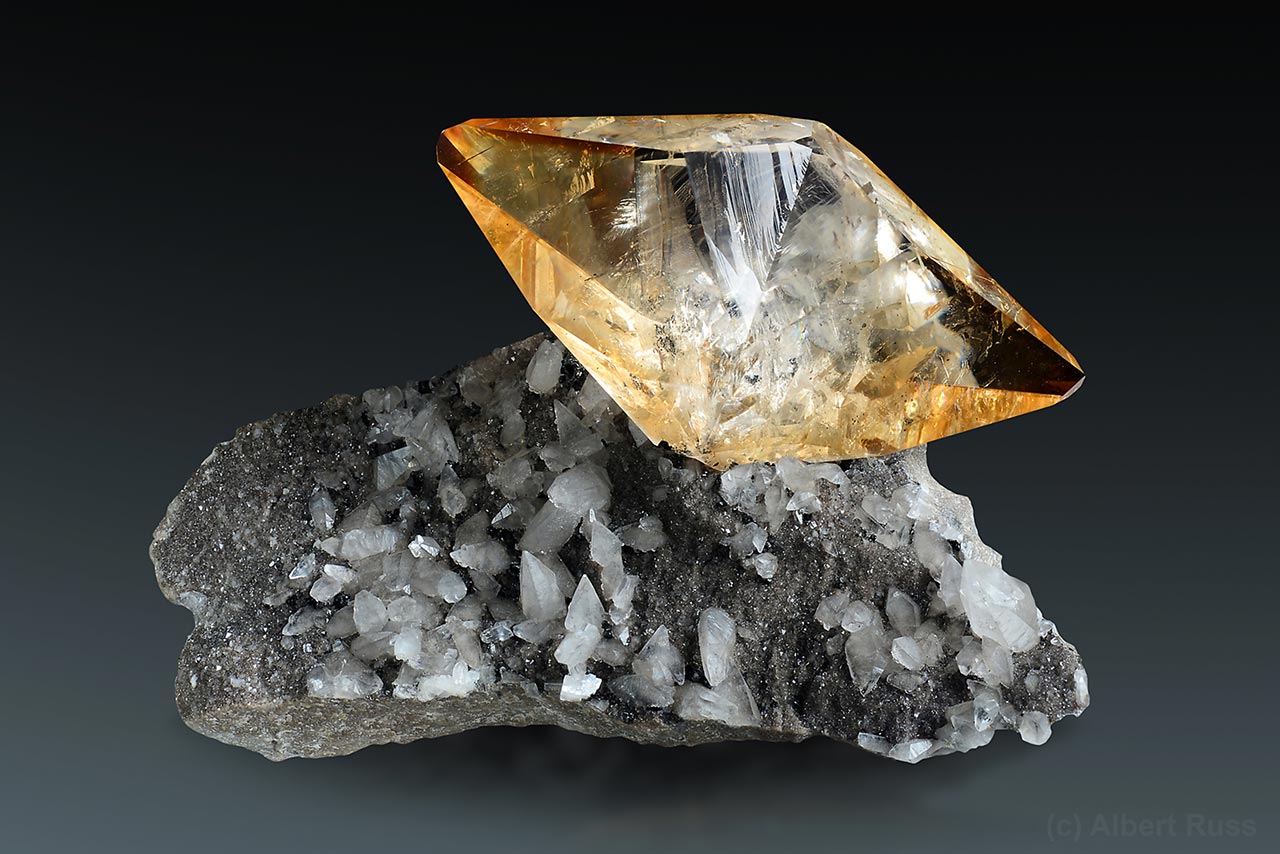 Honey colored calcite scalenohedron sitting on matrix with pale dolomite from Elmwood, TN, USA