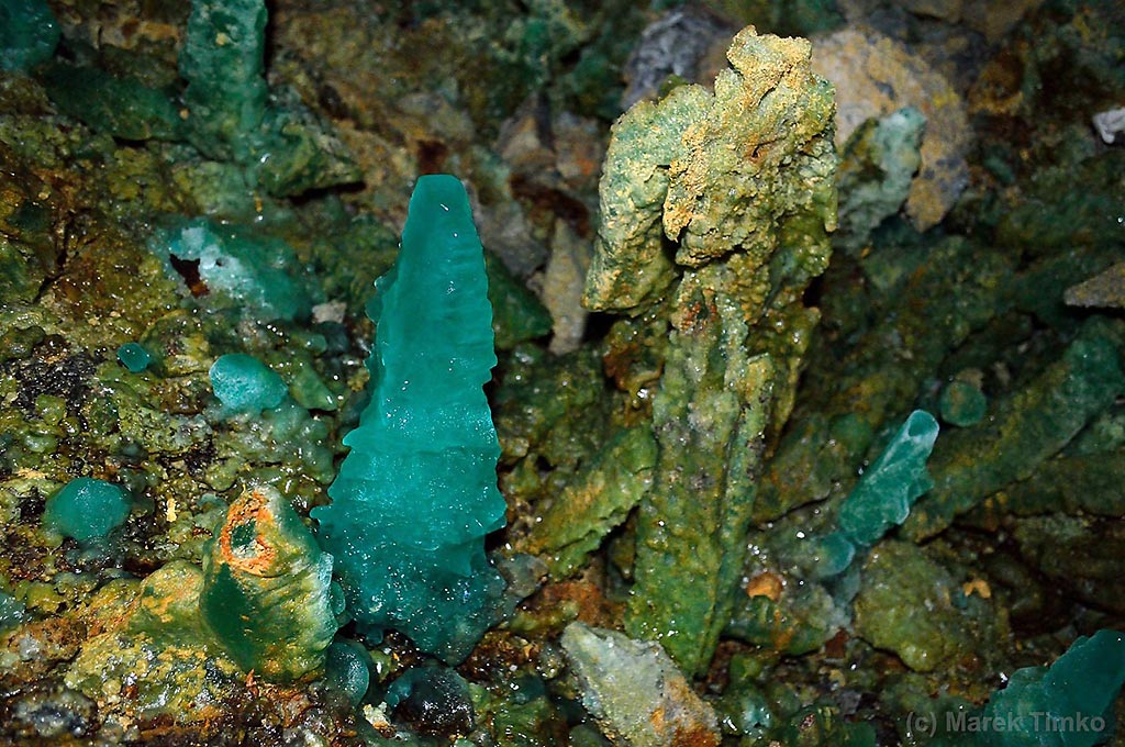 Fresh bright green melanterite stalagmites and encrustations, associated with older partially dehydrated and oxidized melanterite with yellow and rusty parts