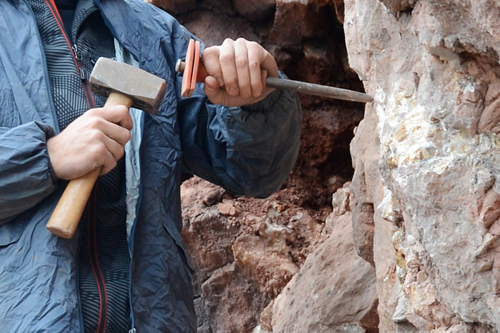 Mineral collector chiseling specimens from the country rock