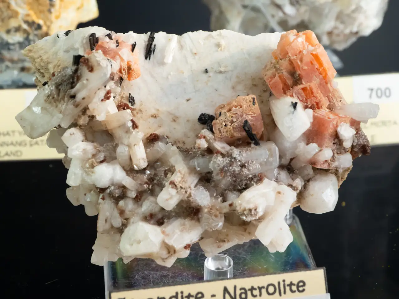 Serandite (orange), natrolite and analcime on feldspar from Poudrette Quarry, Quebec, Canada