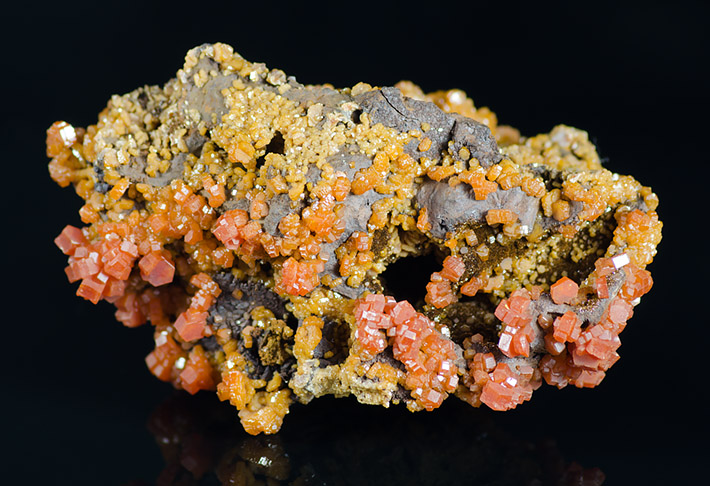 Dark oxides with yellow and orange vanadinite crystals from Mibladen, Morocco